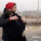 A woman crying on another woman's shoulder after a strike in Ukraine