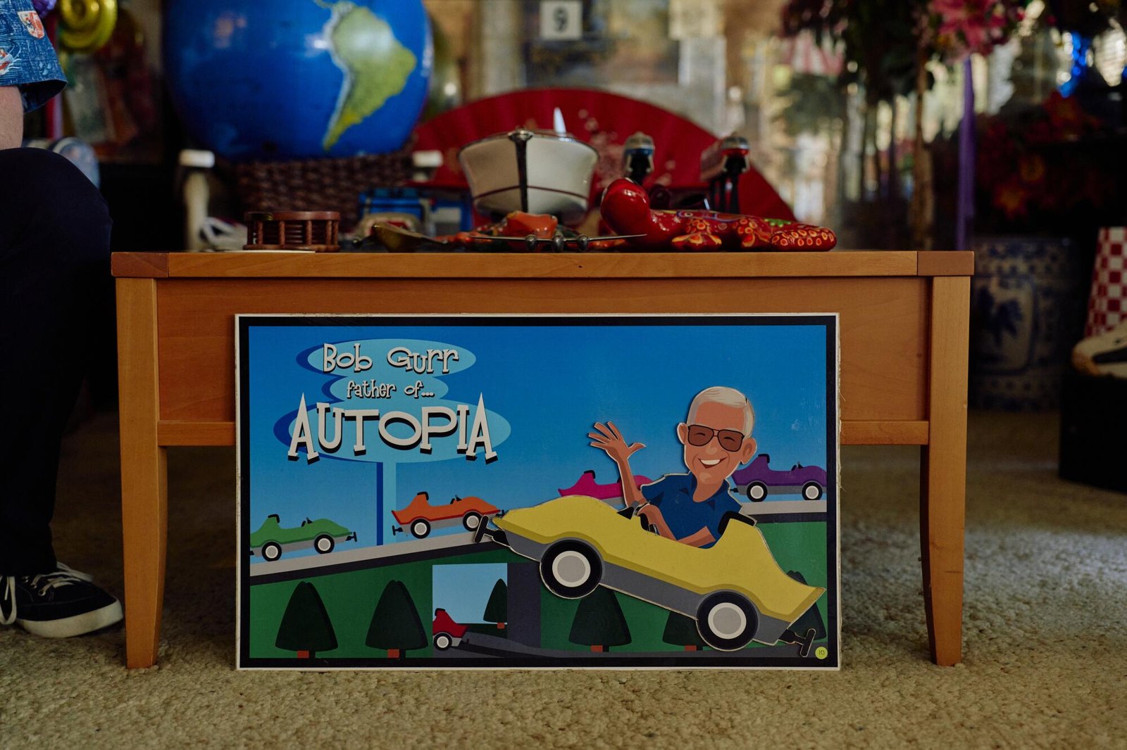 A cartoon caricature of Bob Gurr in an Autopia car. 