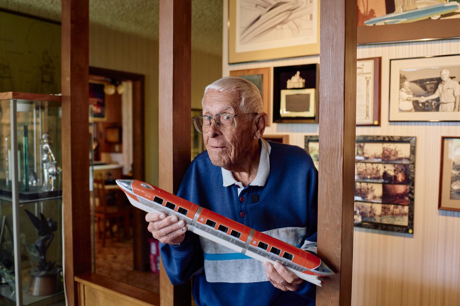 Bob Gurr proudly holding a monorail model.