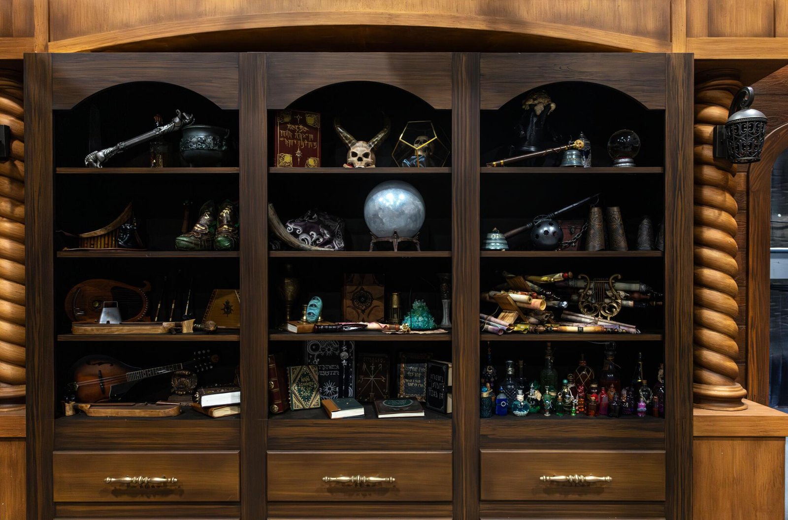 A bookshelf with an odd assortment of magic-like objects. 