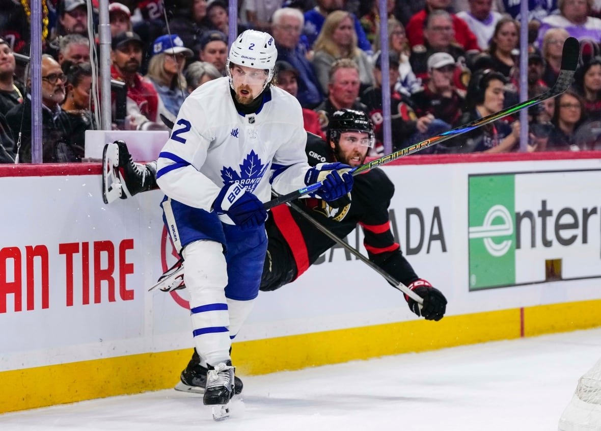 Ottawa Senators' Michael Amadio (22) gets knocked off his skates after a hit into the boards by Toronto Maple Leafs' Simon Benoit (2) during second period NHL playoff hockey action in Ottawa, on Thursday, May 1, 2025. THE CANADIAN PRESS/Justin Tang