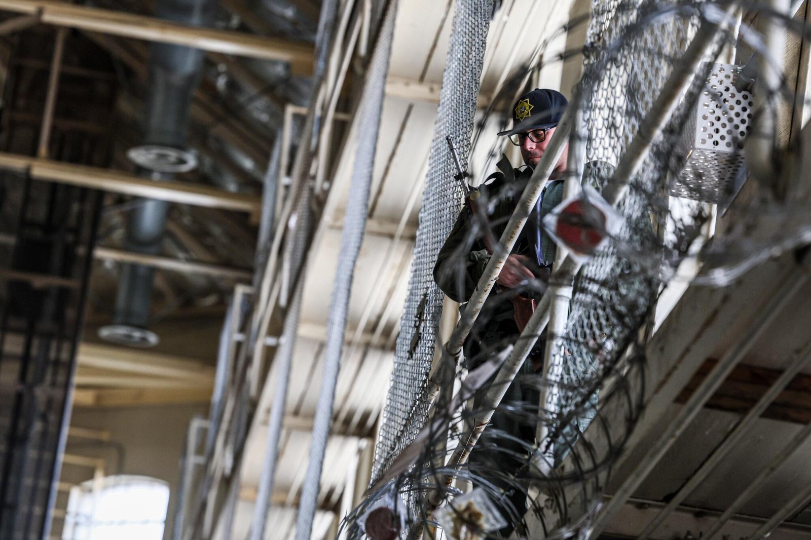 A person stands watch near barbed wire