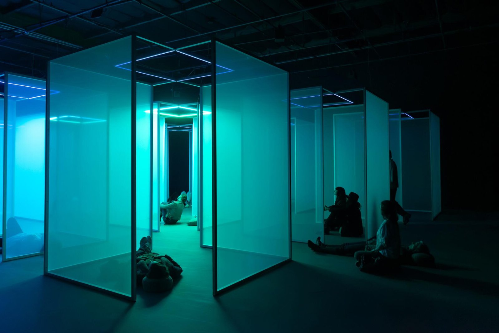 People sitting and lying down amid translucent scrims.