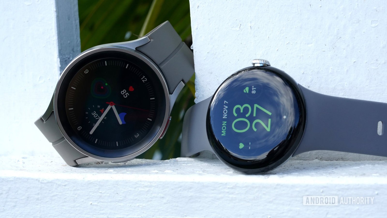 Google Pixel Watch vs Galaxy Watch 5 Series A Google Pixel Watch rests alongside a Galaxy Watch 5 pro.