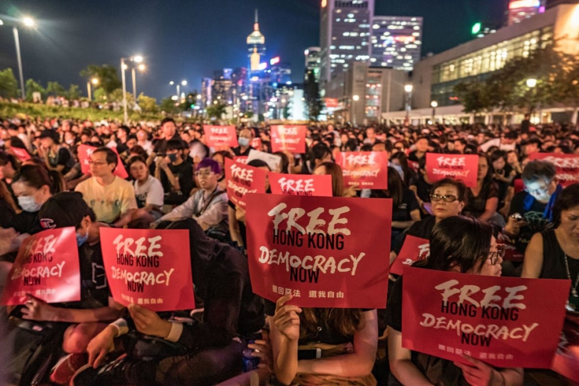 Protesters hold placards that read: Free Hong Kong Democracy Now.