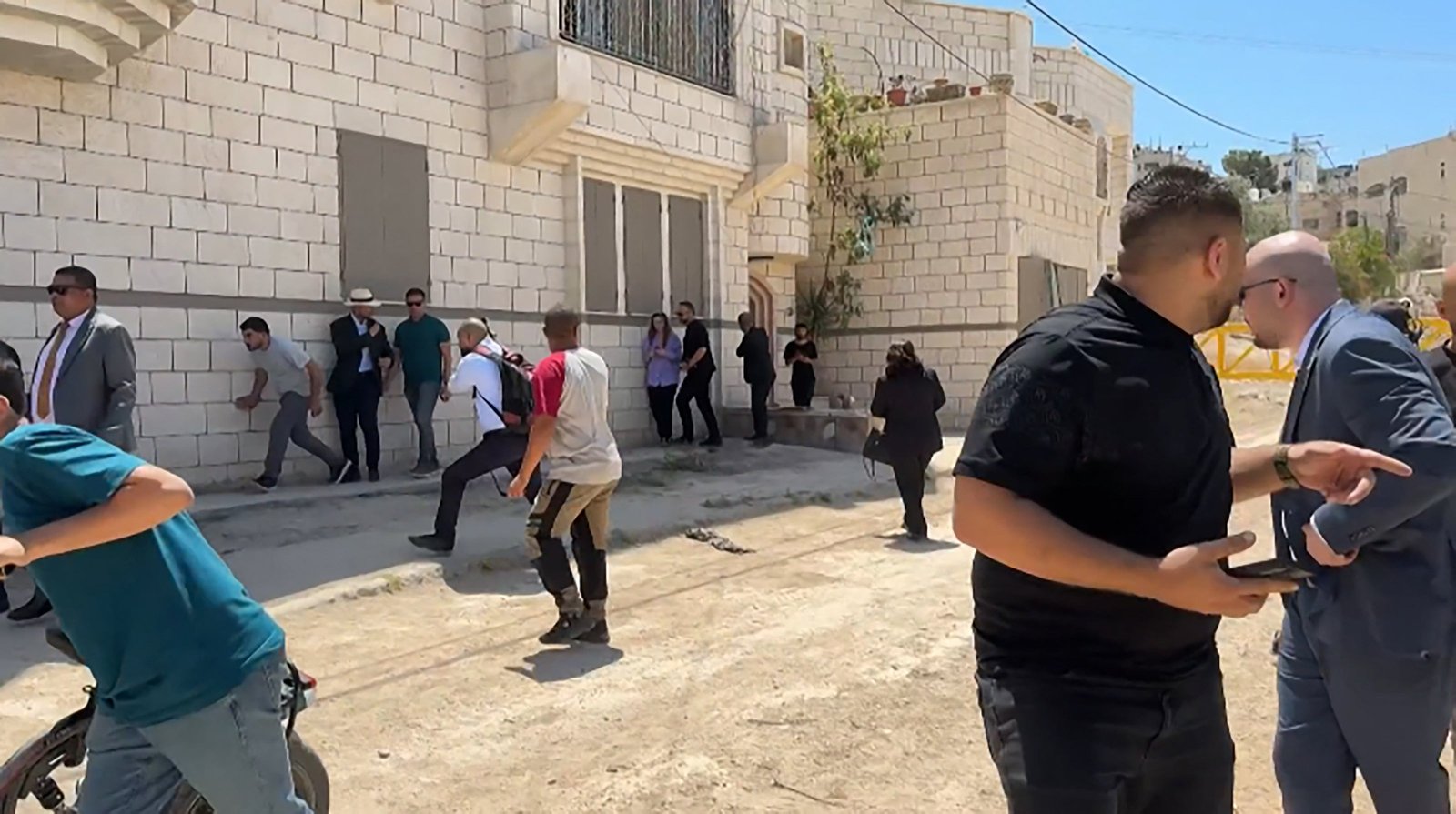 This frame grab from AFPTV footage shows members of a diplomatic delegation from the European Union reacting after shots were fired as they gathered in the eastern entrance of Jenin camp