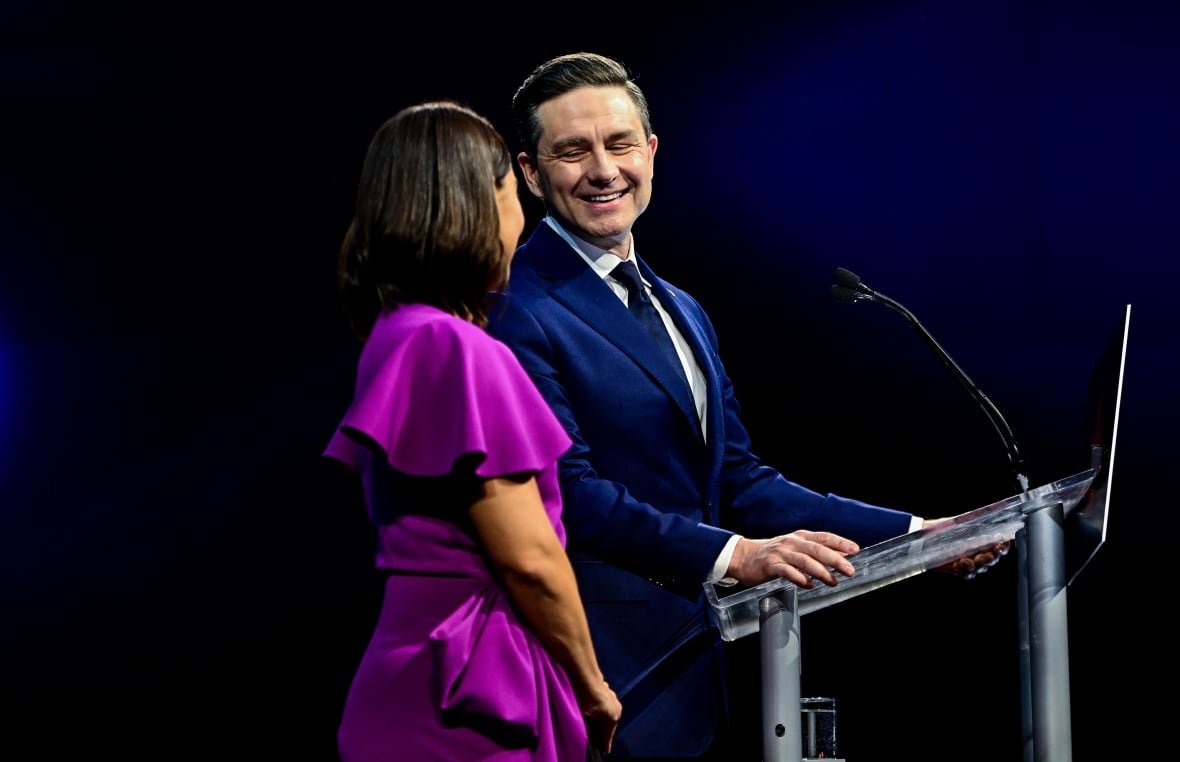 A man and a woman stand at a podium.
