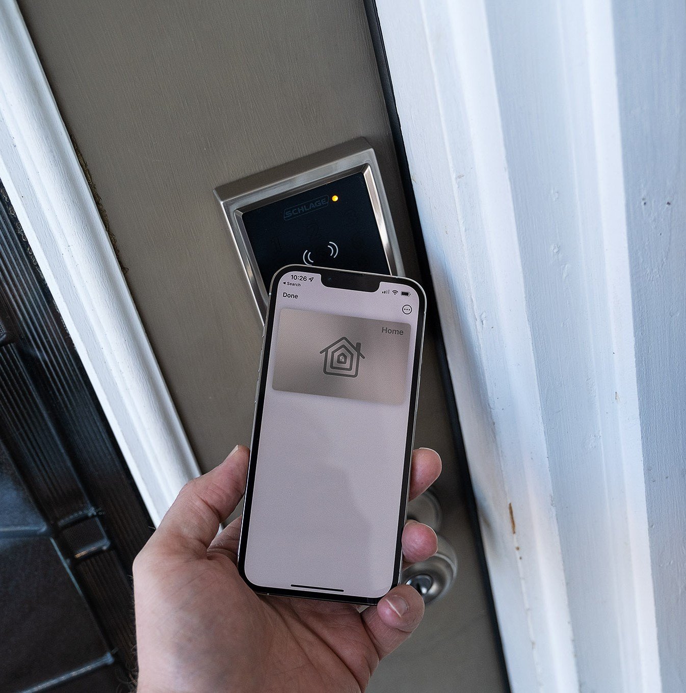 An iPhone being used to unlock the Schlage Encode Plus smart lock.