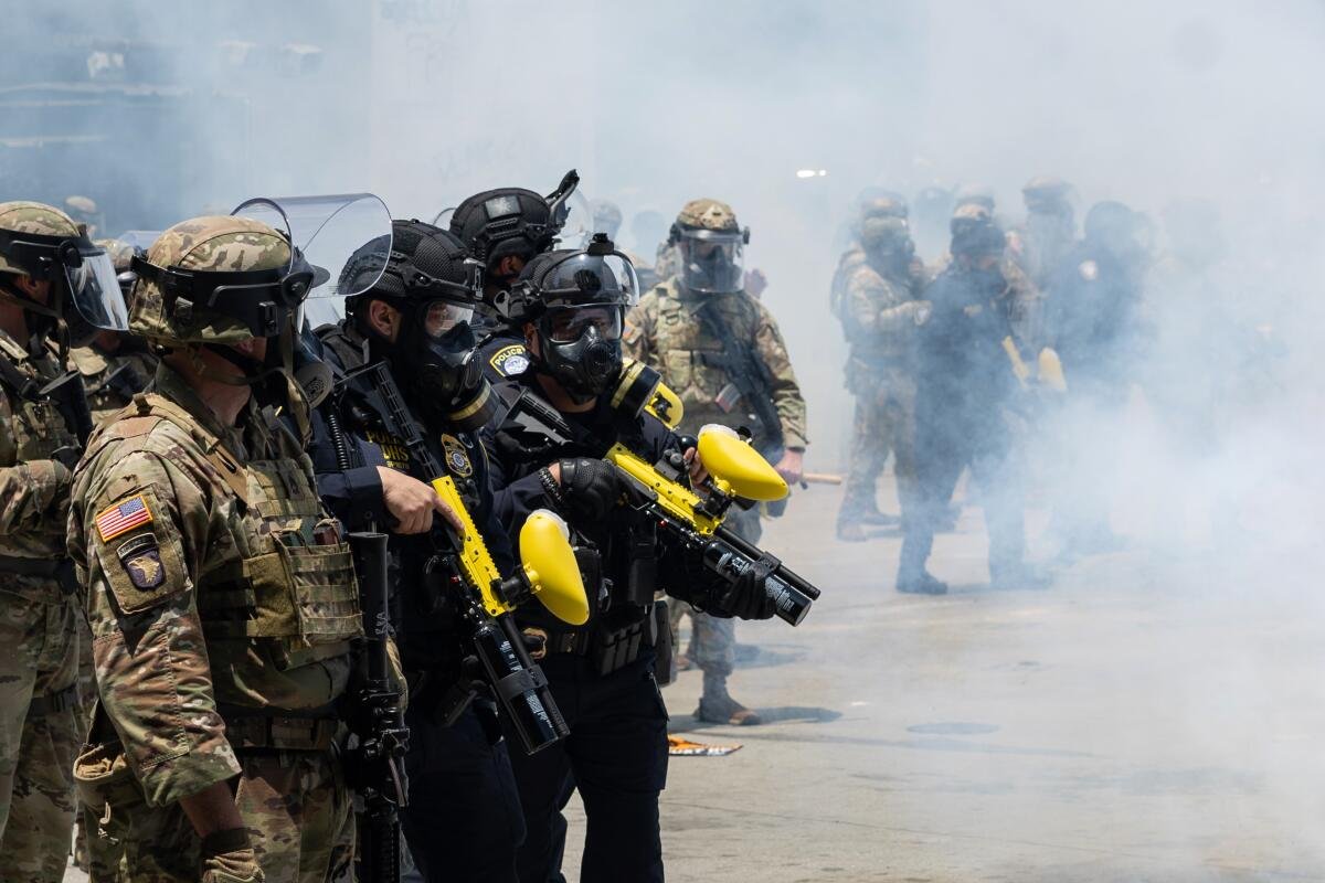 California National Guard troops watch as protesters clash with law enforcement in downtown Los Angeles.