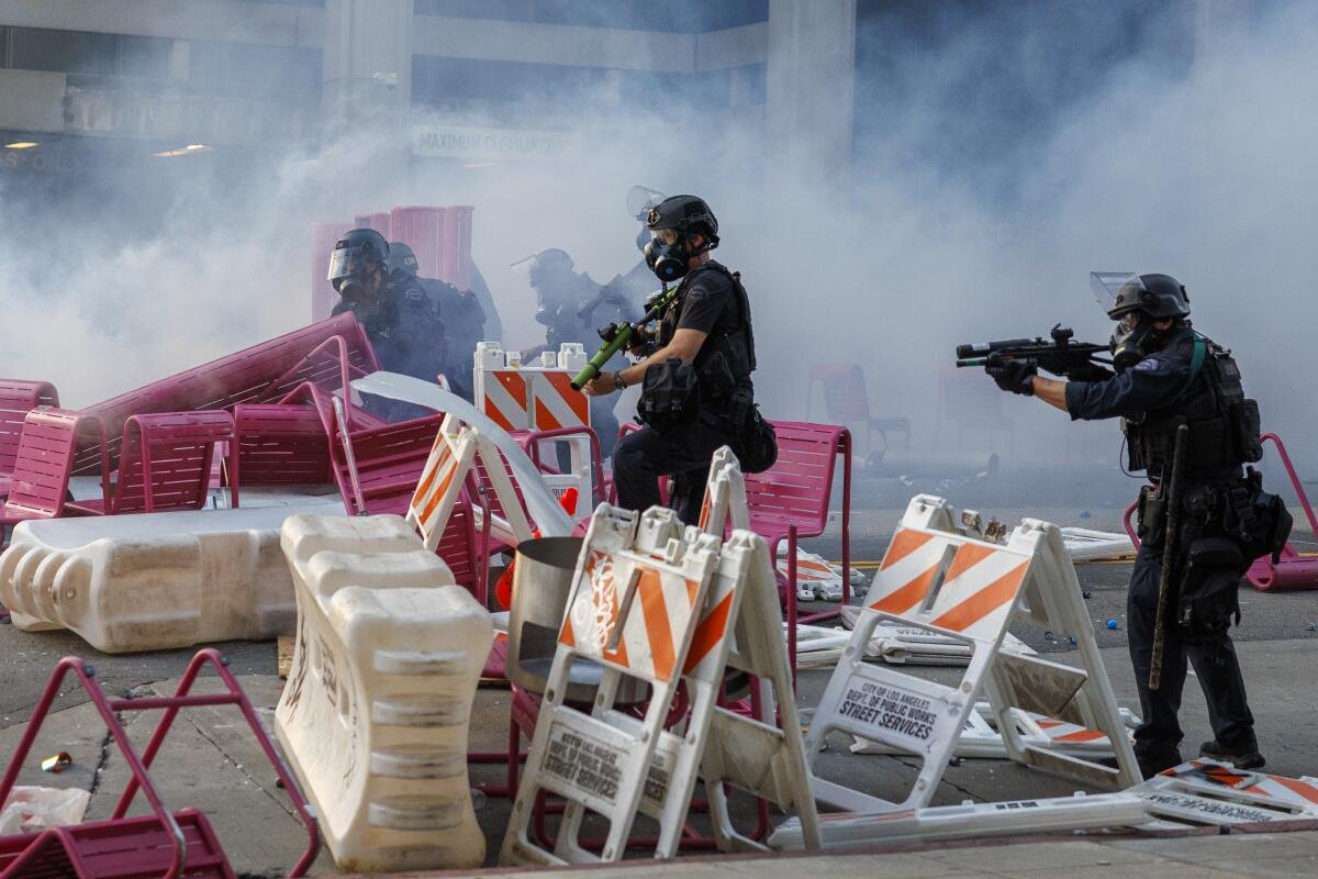Los Angeles Police Department officers shoot tear gas as they advance on demonstrators who formed a makeshift barricade.