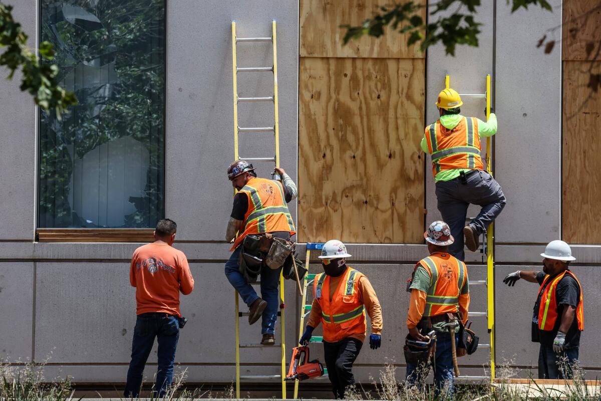 City workers repair broken windows on Spring Street at Police Headquarters. 