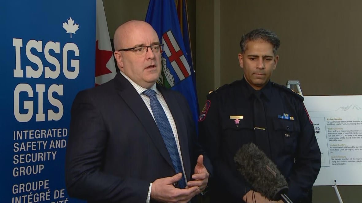 Two men stand in front of a microphone.