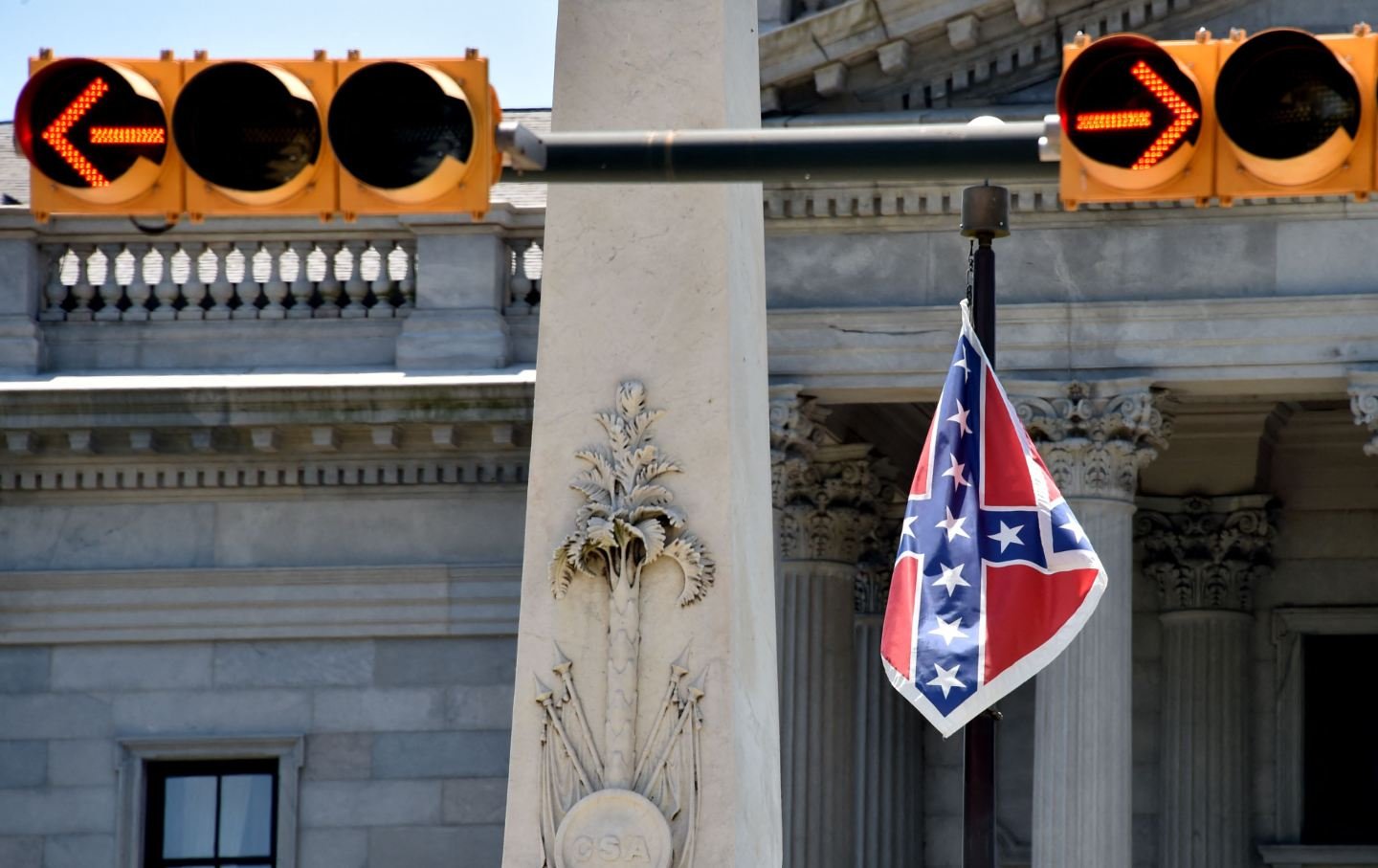 The Confederate flag is seen waving behind the monument of the victims of the Confederation Army during the American Civil War in front of the State Congress building in Columbia, South Carolina, on June 19, 2015.