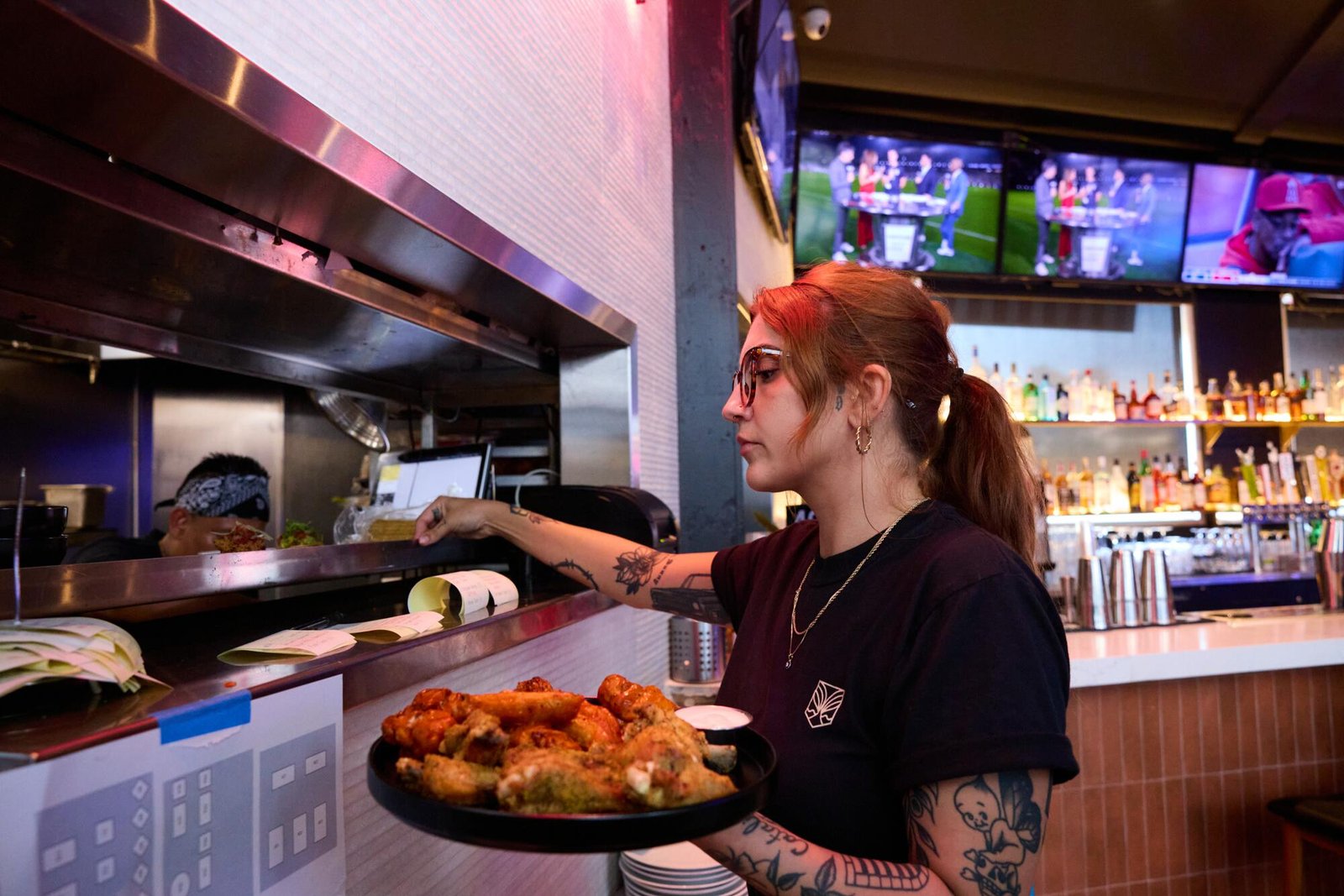 An employee cooking wings at Untamed Spirits