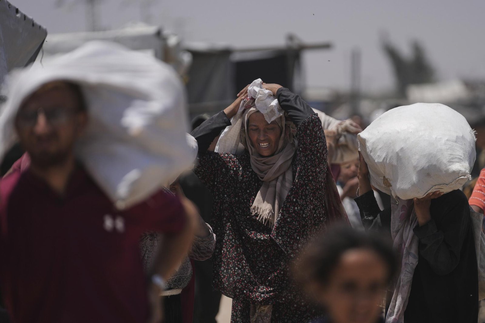People carrying bags containing food and other aid