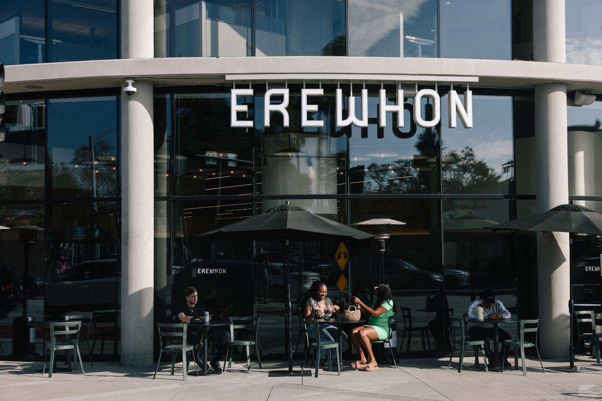 People sit at cafe tables outside Erewhon.