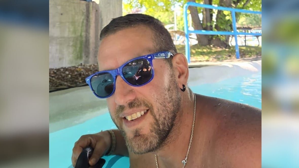 A man smiles with sunglasses on