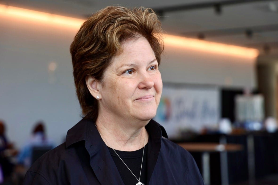Portrait of a woman with short brown hair and a black shirt.