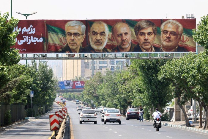 A poster displaying the portraits of Iranian military generals and nuclear scientists killed in Israel’s attack hangs on a bridge in Tehran