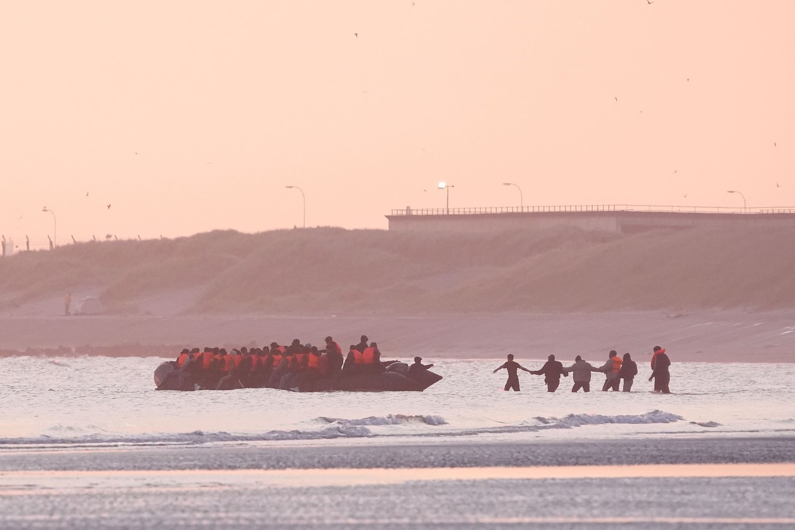People thought to be migrants board a small boat leaving the beach at Gravelines, France (Gareth Fuller/PA)