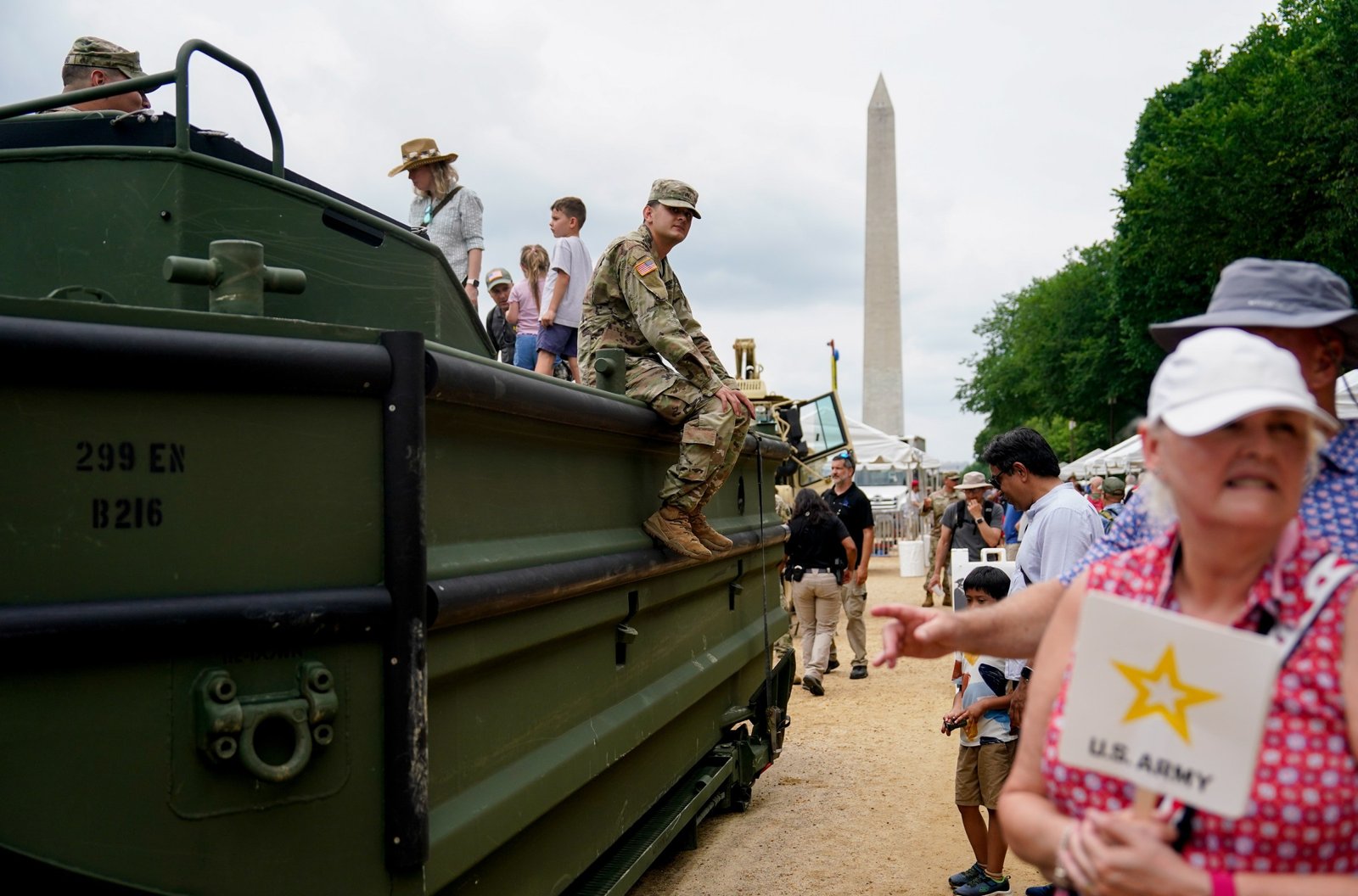 Attendees look at a military vehicle on display.