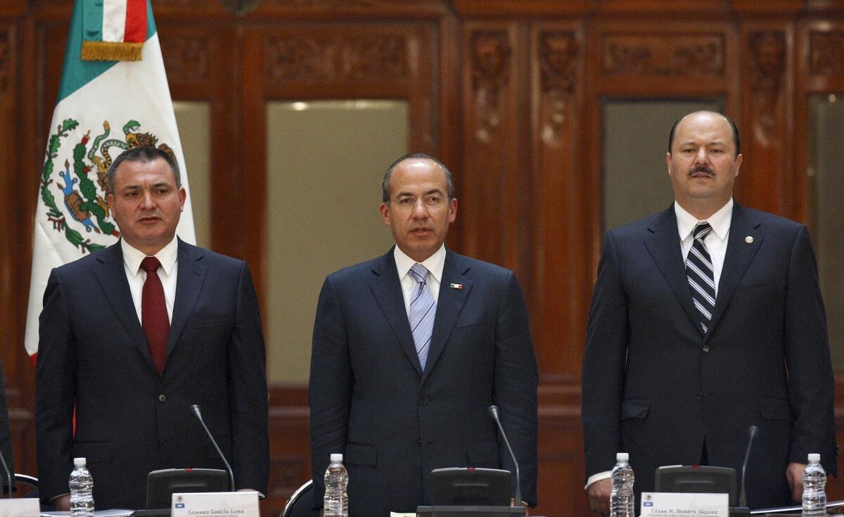 Mexico's President Felipe Calderón, center, stands alongside Mexico's Public Safety Secretary Genaro García Luna.