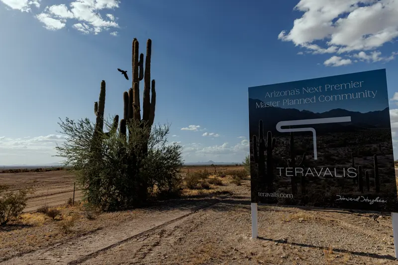 A sign in the desert that says "Teravalis: America's Next Premier Master Planned Community."