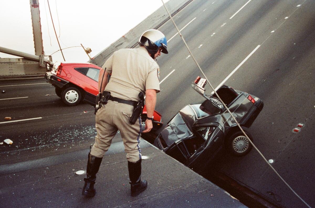 A CHP officer checks damage after the Loma Prieta earthquake in San Francisco on Oct. 17, 1989. 