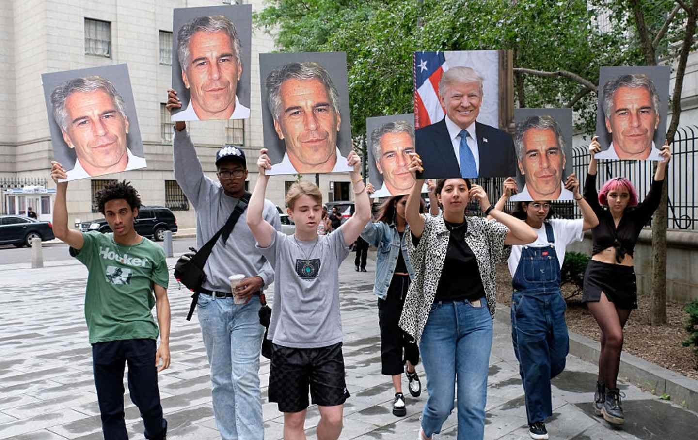 A group of young protesters holds pictures of Jeffrey Epstein and Donald Trump outside the Federal Court in downtown Manhattan.