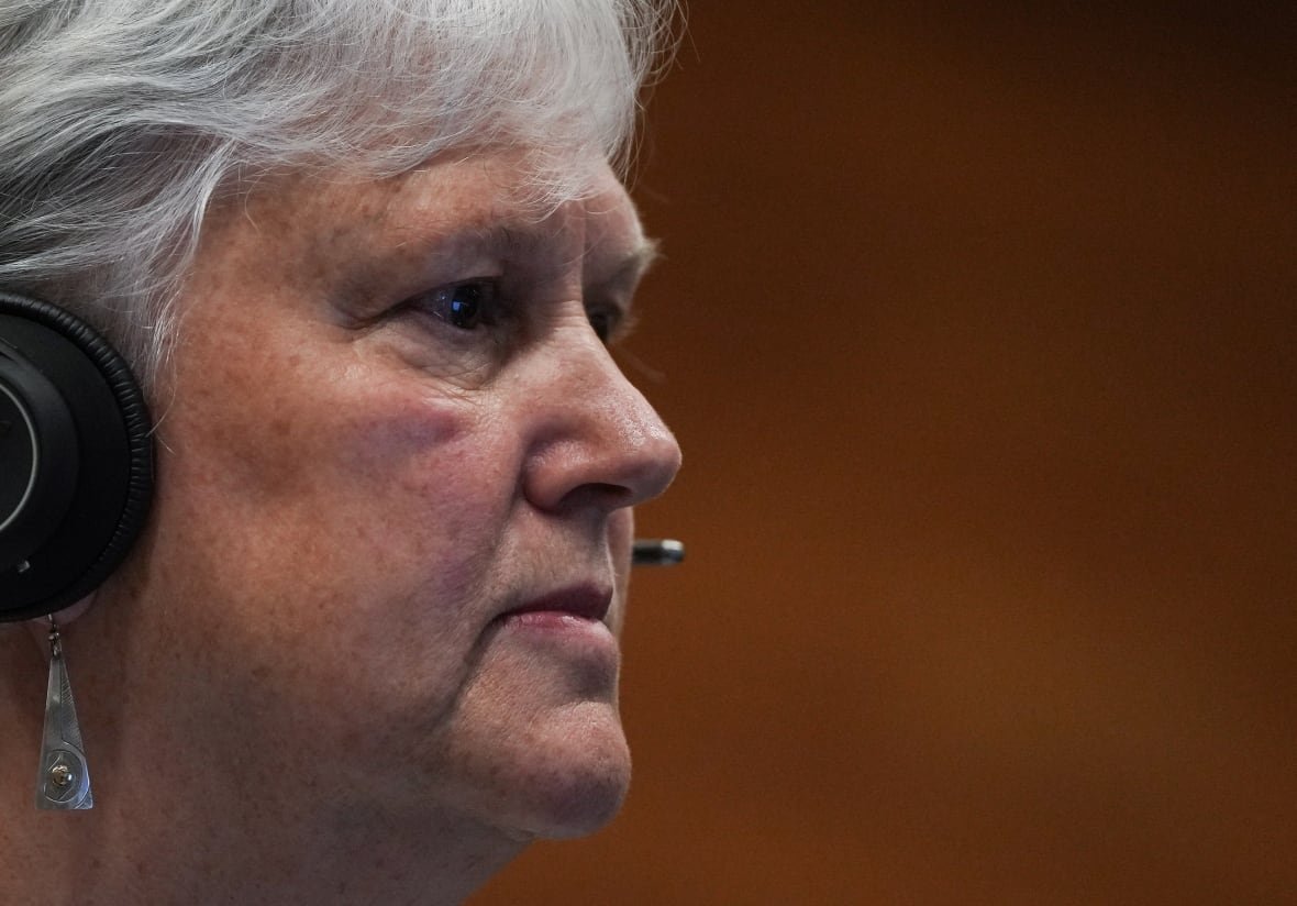 A woman wearing a headset is seen in profile.