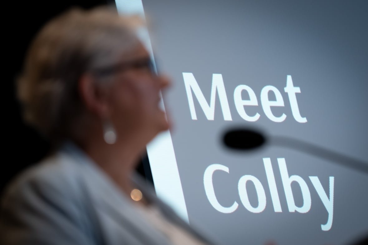 A woman is pictured in silhouette while a slide behind her reads 'Meet Colby'.