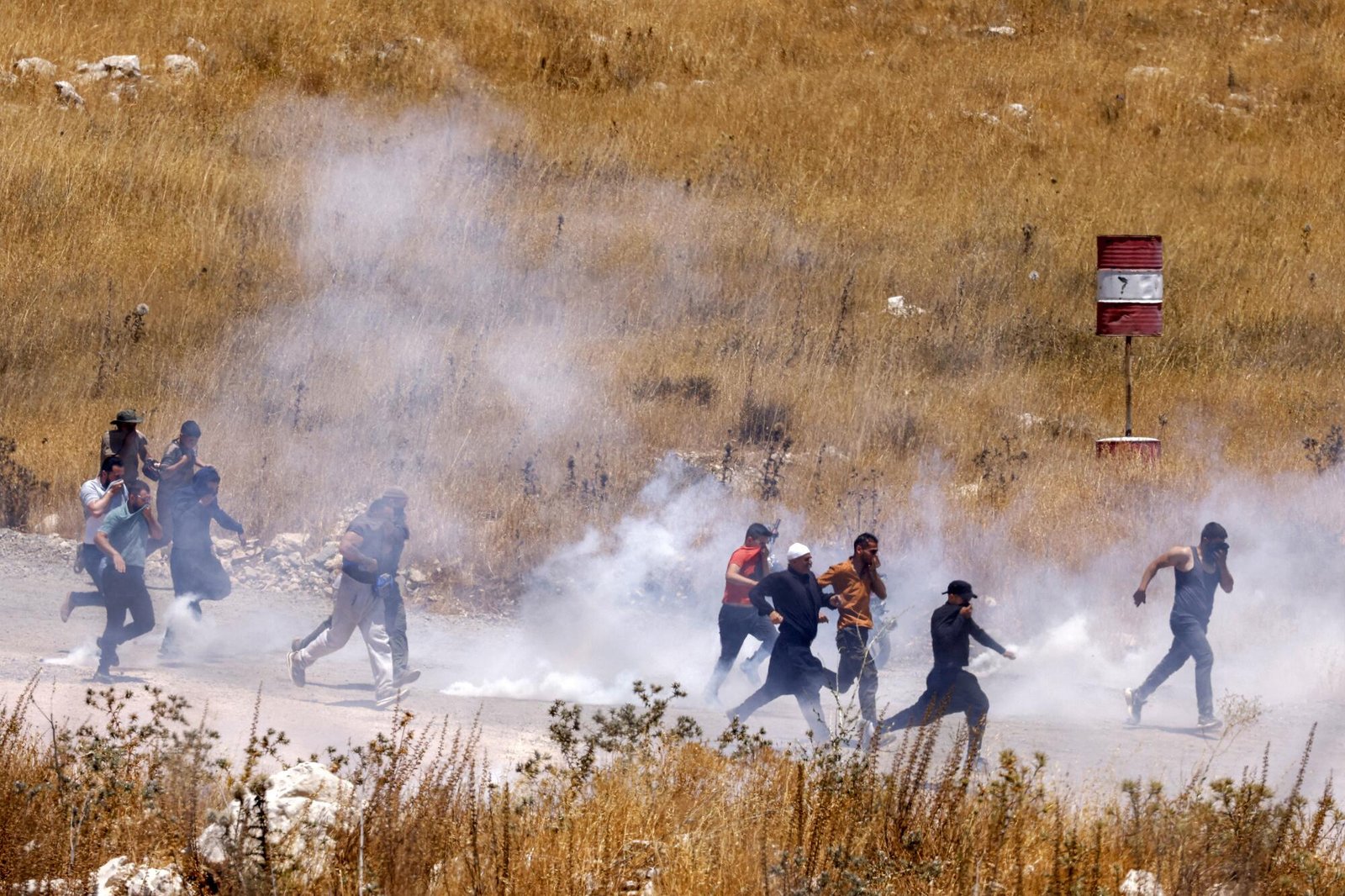 Members of Syria's Druze community walk through tear gas fumes released by Israeli forces