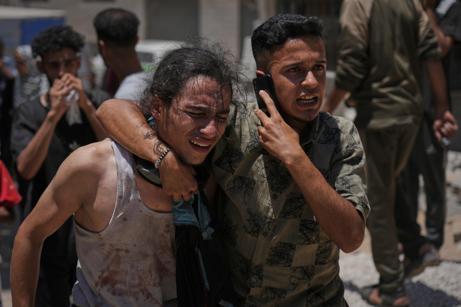 Palestinians react to the killing of friends and relatives while waiting for aid trucks