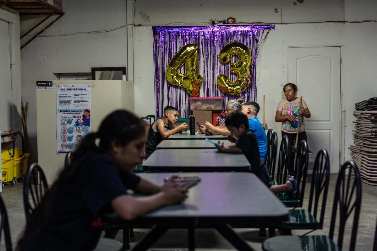 Migrants pass the time at Oasis de Migrante shelter in Juárez.
