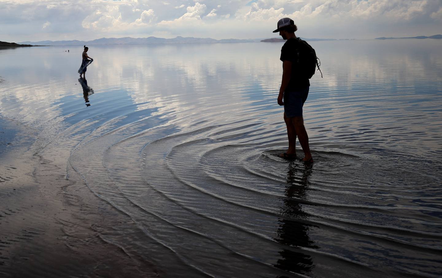 People wade in the waters of the Great Salt Lake at Antelope Island in August 2021.
