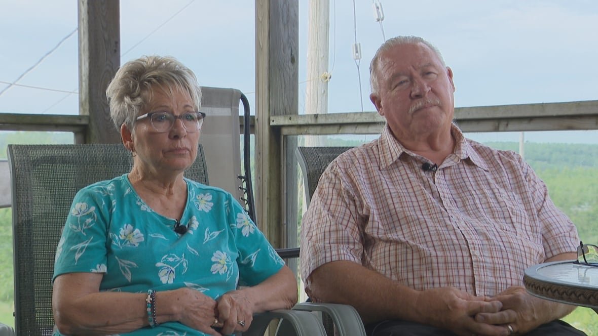 A woman and a man sit next to each other in chairs.