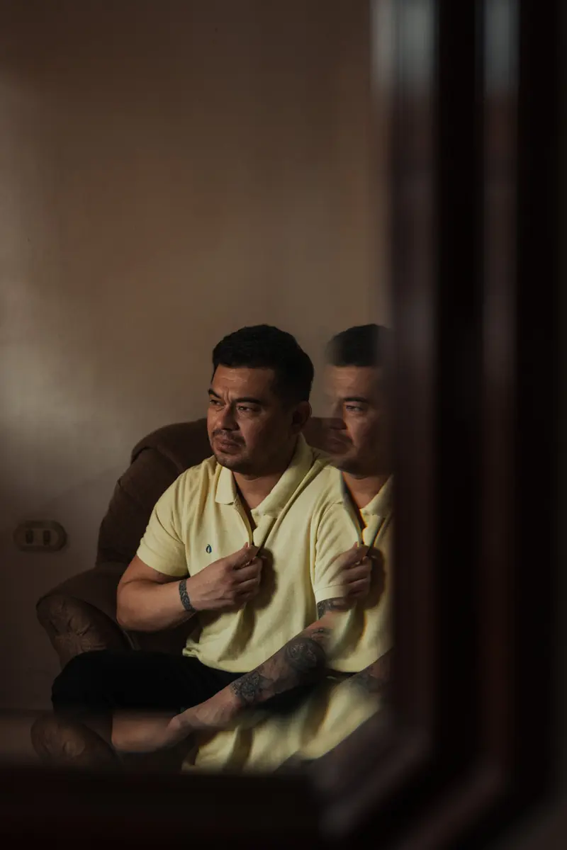 Andry Omar Blanco Bonilla holds his hand to his chest while seated in a chair.