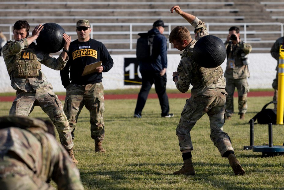 men compete in the agility course with exercise ball