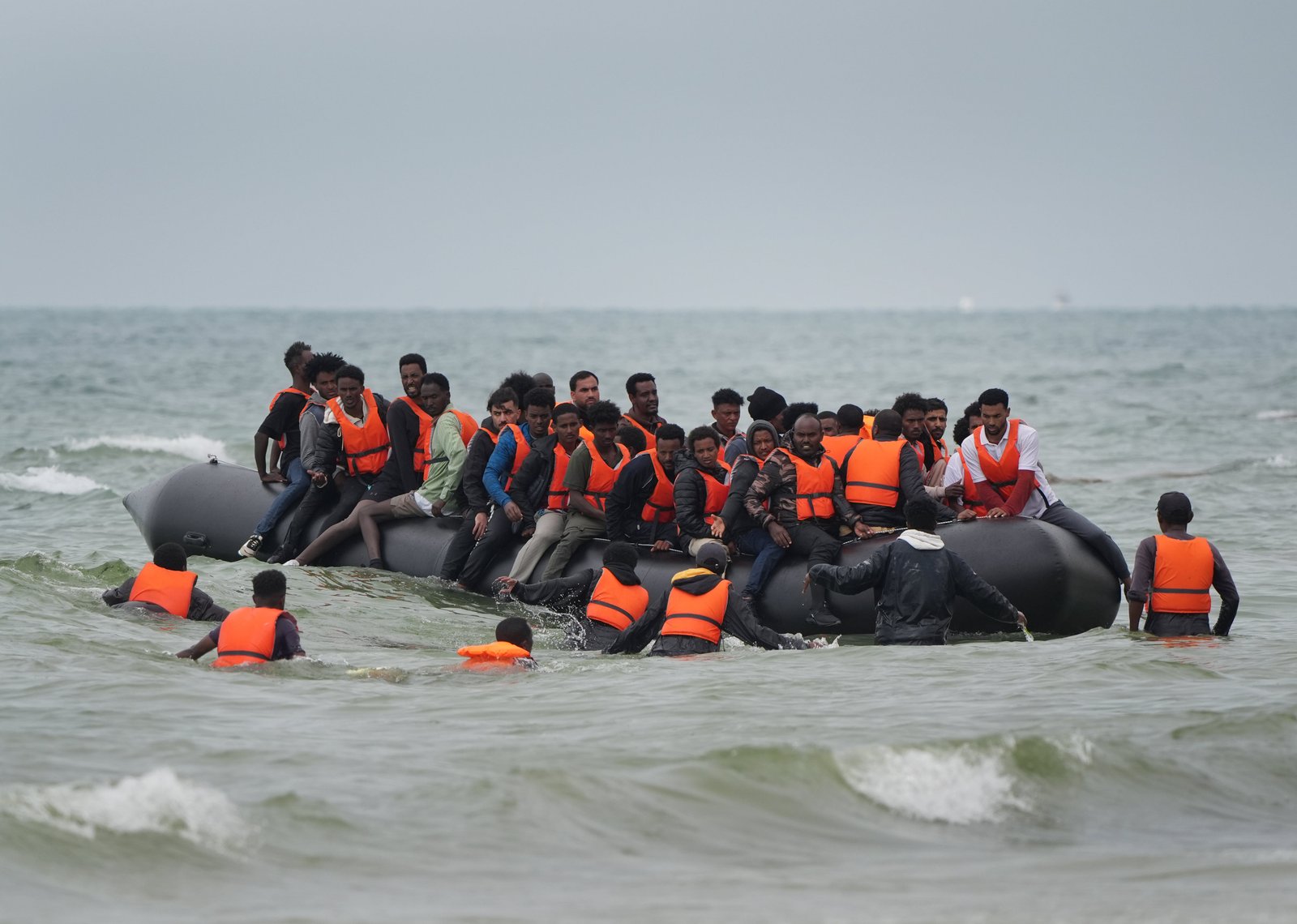 People thought to be migrants scramble to board a small boat near Wimereux in France in July